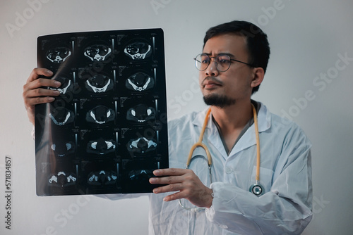 Doctor analyzing x-ray of the patient's spine in a medical clinic. 