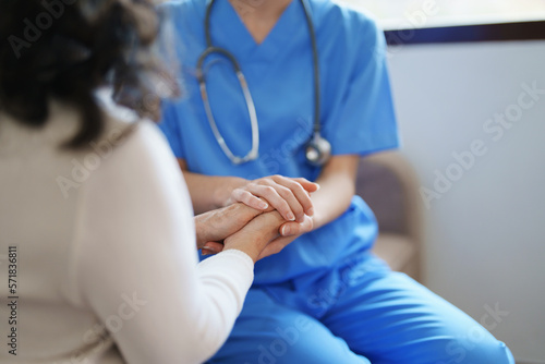 Portrait of a female doctor holding a patient's hand to encourage the fight against disease. © Jirapong