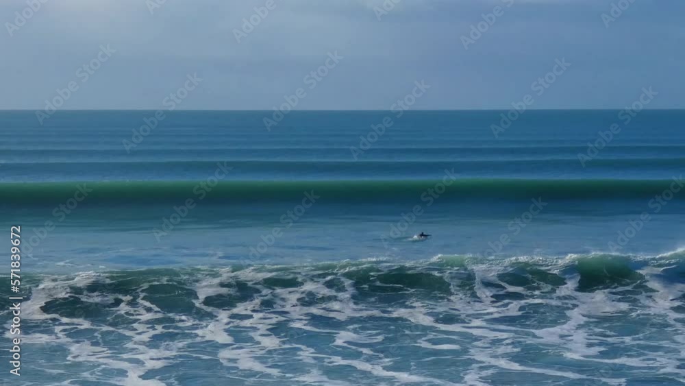 Lone surfer briefly appears between breaking waves on a beautiful mid-winter's morning - New Brighton Beach, Christchurch (New Zealand) Lone surfer briefly appears between breaking waves on a beautiful mid-winter's morning - New Brighton Beach, Christchurch (New Zealand)