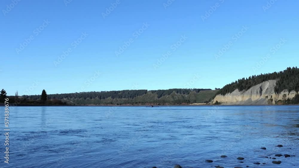 Early-morning kayaker paddles upstream on a beautiful mid-winter's day - Rakaia River Gorge (New Zealand) Early-morning kayaker paddles upstream on a beautiful mid-winter's day - Rakaia River Gorge (New Zealand)