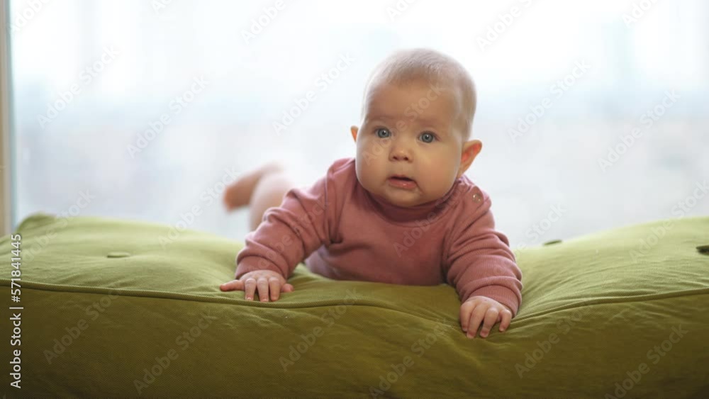 Portrait of a baby. Child lying on his stomach, close-up, looking at the cameraman Portrait of a baby. Child lying on his stomach, close-up, looking at the cameraman