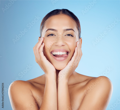 Skincare, beauty and woman with tongue out in studio for makeup, cosmetics and wellness. Happy model, portrait smile and clean teeth whitening for aesthetics, facial salon and glow on blue background