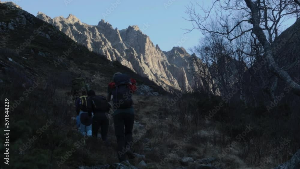 Slow motion shot of hiker group trekking on rocky path in Norwegian mountains during sunny day Slow motion shot of hiker group trekking on rocky path in Norwegian mountains during sunny day