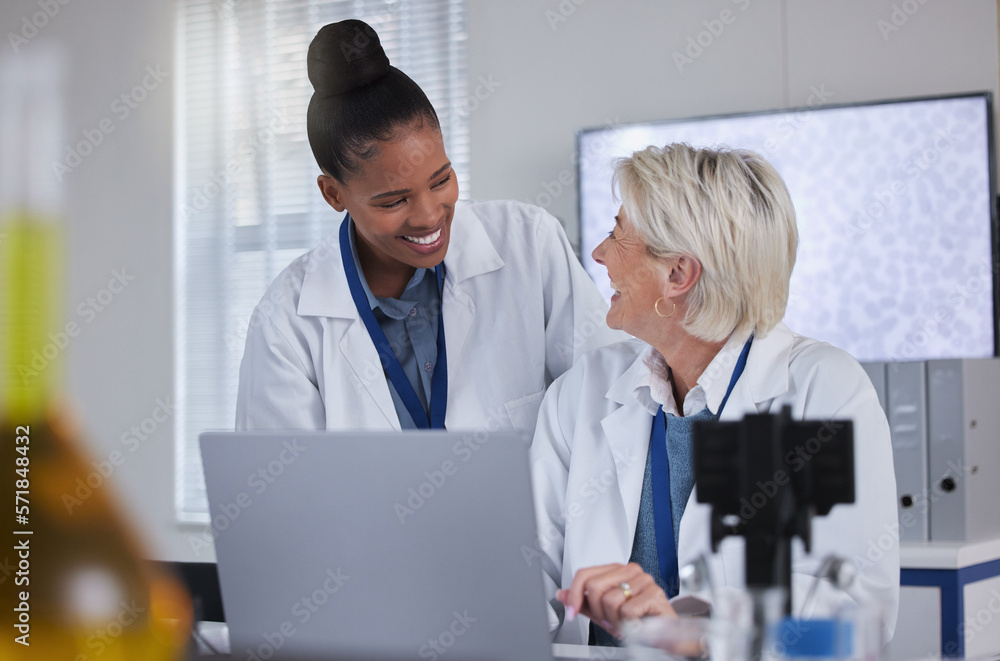 Teamwork, laptop and collaboration of doctors in laboratory for medical research or science. Computer, comic and researchers, black woman and senior female, talking and laughing at funny comedy meme. Teamwork, laptop and collaboration of doctors in laboratory for medical research or science. Computer, comic and researchers, black woman and senior female, talking and laughing at funny comedy meme.