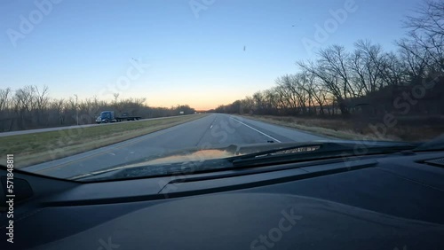 Point of view; through windshield while driving at dawn on a interstate with little traffic; early morning of late Autumn in American Midwest photo