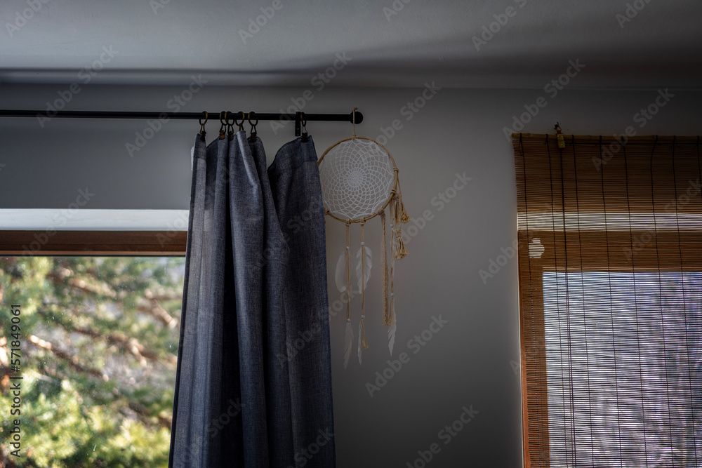 Handmade Dreamcatcher hanging on a ledge with a curtain by the window in the room