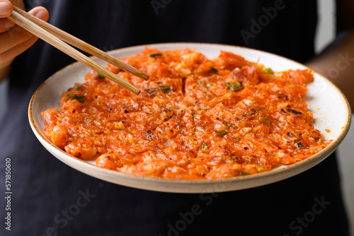 Kimchi pancake (Kimchi jeon or kimchi buchimgae) with hand ready to eating, Korean food photo