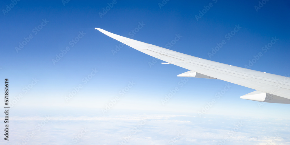 white wing of an airplane against clear blue sky, clouds. Template, banner design. concept of travel white wing of an airplane against clear blue sky, clouds. Template, banner design. concept of travel