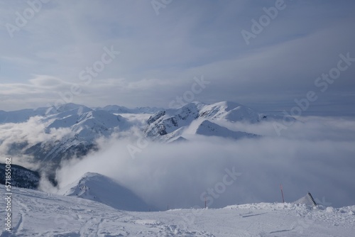 Amazing scenery of snowy clouds in clouds from Kasprowy Wierch Peak in Tatras Mountains. Tatra National Park, Poland. Dramatic clouds scenery.