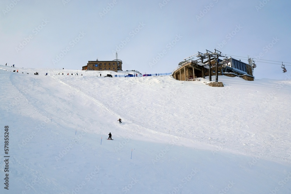 Little silhouettes of skier on slope of Kasprowy Wierch Peak in Tatras Mountains, famous place in Tatras with cable railway. Poland. Dramatic clouds scenery. Little silhouettes of skier on slope of Kasprowy Wierch Peak in Tatras Mountains, famous place in Tatras with cable railway. Poland. Dramatic clouds scenery.