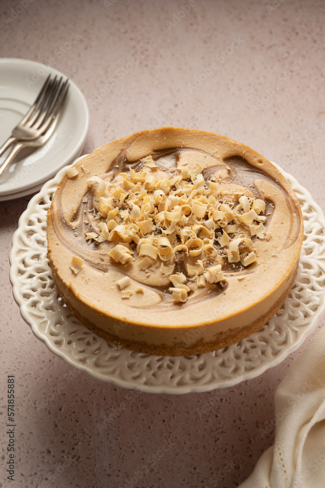 Whole caramel cheesecake served with cup of tea, top view. Whole caramel cheesecake served with cup of tea, top view.