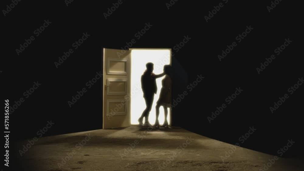 Side view of couple standing opposite and looking each other in front of an open door with white light behind . Footage of couple stand on floor behind stars. Concept of dream or romance. Slow Motion Side view of couple standing opposite and looking each other in front of an open door with white light behind . Footage of couple stand on floor behind stars. Concept of dream or romance. Slow Motion