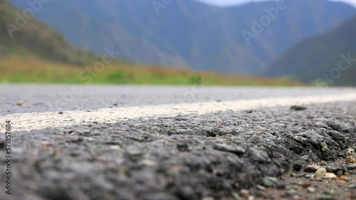 Wallpaper Mural Close-up of an asphalt road on which a car drove with its headlights on. On wet asphalt in the foothills, travelers drive by car with their headlights on. Torontodigital.ca
