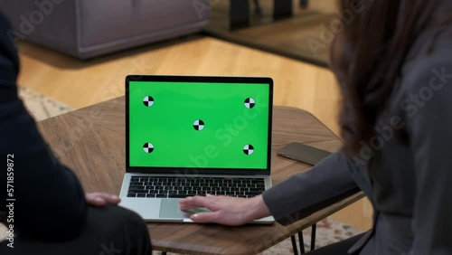 A man and a woman discuss what they saw on the green screen. Colleagues actively gesticulate, pointing and scrolling with a touchpad. Important negotiations in the office. Business meeting of managers