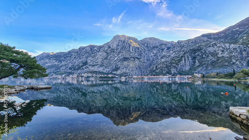Panoramic view of bay of Kotor on sunny summer day at Adriatic Mediterranean Sea  Montenegro  Balkans  Europe. Fjord winding along coastal towns. Lovcen mountains are reflected in the water surface