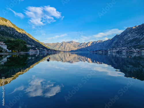 Panoramic view of bay of Kotor on sunny summer day at Adriatic Mediterranean Sea, Montenegro, Balkans, Europe. Fjord winding along coastal towns. Lovcen mountains are reflected in the water surface