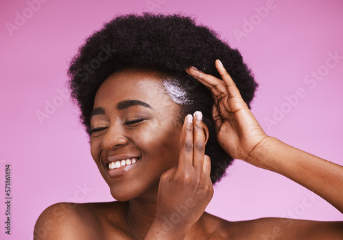 Happy black woman, afro hair and conditioner treatment for ethnic texture on pink studio background. African model, haircare cosmetics and cream product for scalp, skin relaxer and beauty maintenance photo