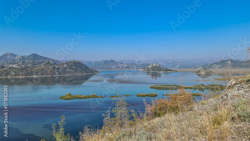Scenic view on beautiful lake of Skadar National Park on sunny autumn day seen from Vranjina  Bar  Montenegro  Balkans  Europe. Travel destination  Dinaric Alps near Albania. Magical water reflection