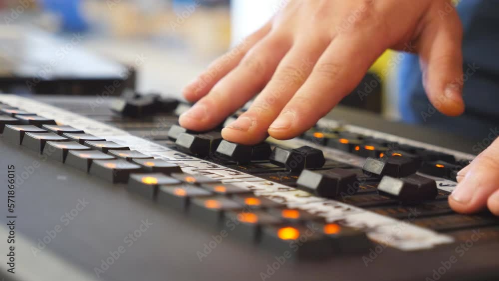Hands of male sound engineer presses the keys and moves buttons of soundboard . Arms of man working on professional digital audio channel mixer. Amplifier and balance of sound. Close up Slow motion Hands of male sound engineer presses the keys and moves buttons of soundboard . Arms of man working on professional digital audio channel mixer. Amplifier and balance of sound. Close up Slow motion