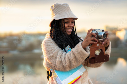 Tourist african american woman with camera taking photos of beautiful location, she's happy and excited about visiting new city