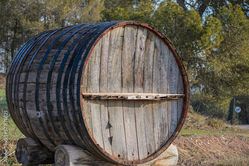 Large wine barrel outside, at the doors of a cellar.
