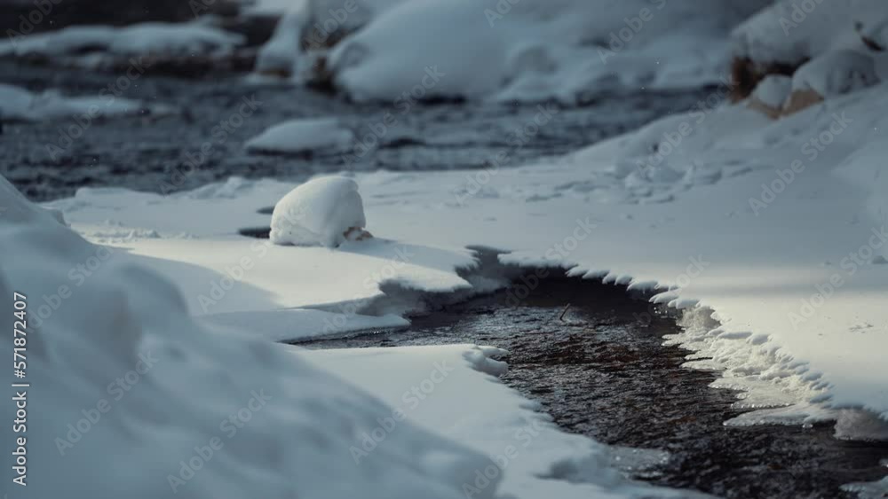 4K video with a beautiful mountain river covered with snow during a winter morning in the forest. Nature landscape film. 4K video with a beautiful mountain river covered with snow during a winter morning in the forest. Nature landscape film.