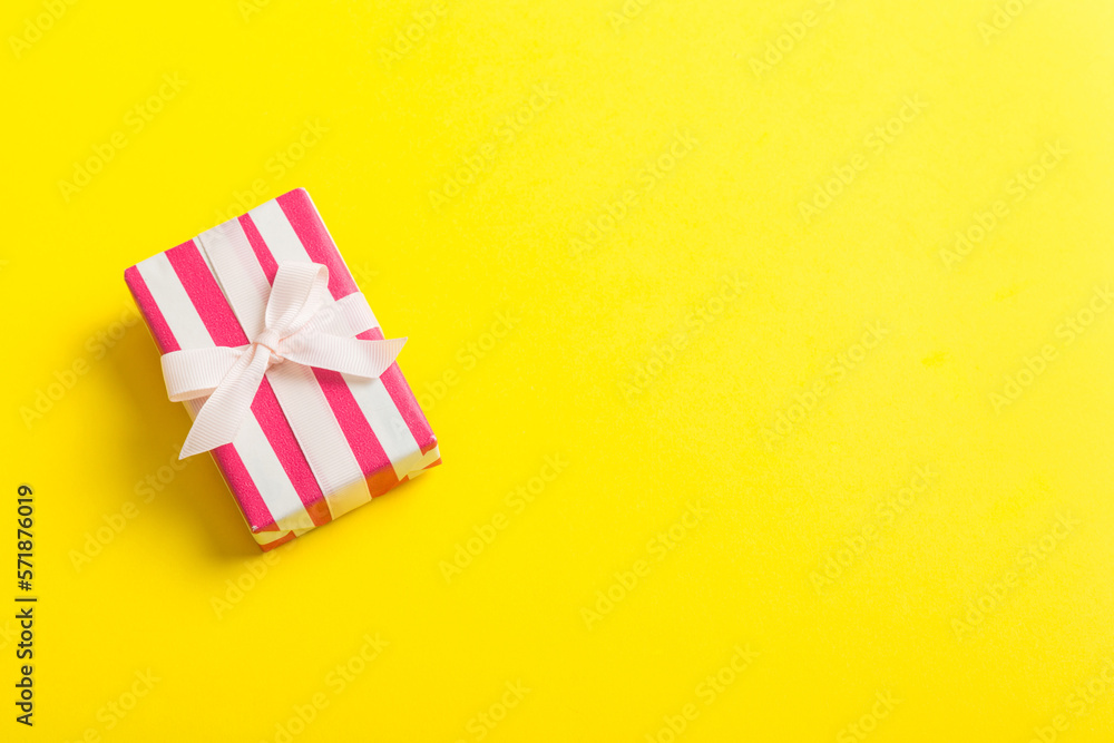 wrapped Christmas or other holiday handmade gift box in color paper with ribbon on colored background. Present box, decoration of gift on colored table, top view with copy space wrapped Christmas or other holiday handmade gift box in color paper with ribbon on colored background. Present box, decoration of gift on colored table, top view with copy space