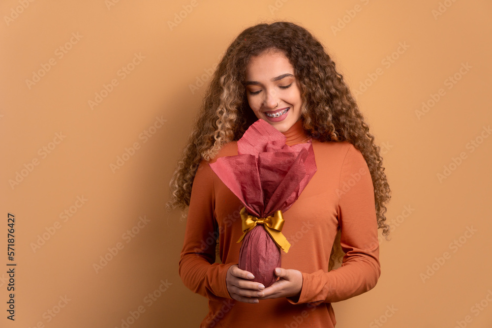 happy brazilian woman with easter egg in all beige colors. holiday, easter, celebration concept. happy brazilian woman with easter egg in all beige colors. holiday, easter, celebration concept.
