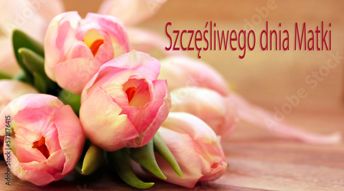 kartka lub baner, aby życzyć szczęśliwego dnia matki w kolorze różowym na beżowym tle z efektem bokeh i obok bukietu różowych i białych tulipanów