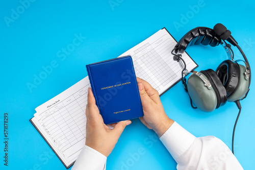 Konstfotografi Woman's hands hold an airline pilot's license against the background of a headse