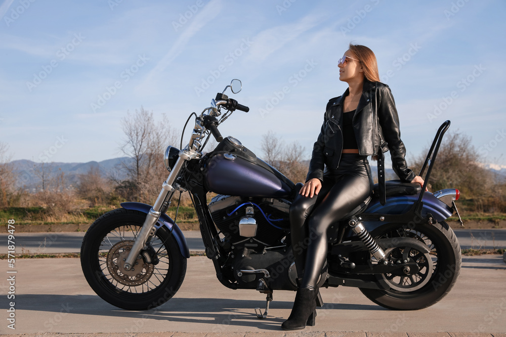 Beautiful young woman sitting on motorcycle outdoors Beautiful young woman sitting on motorcycle outdoors
