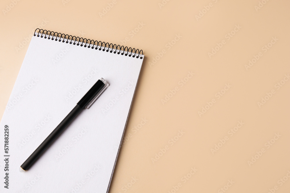 Notepad with erasable pen on beige background, top view. Space for text Notepad with erasable pen on beige background, top view. Space for text