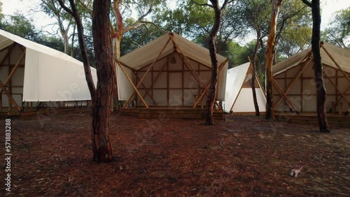 backward drone footage flying out of one of the white tents of a campsite in Huelva, Spain photo