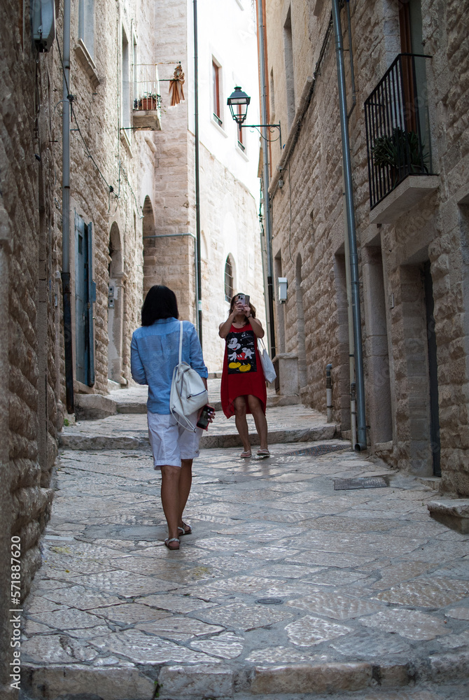 two women travel through an old town in Italy. concept immersive travel. walking in the street