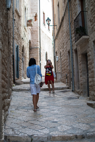 two women travel through an old town in Italy. concept immersive travel. walking in the street