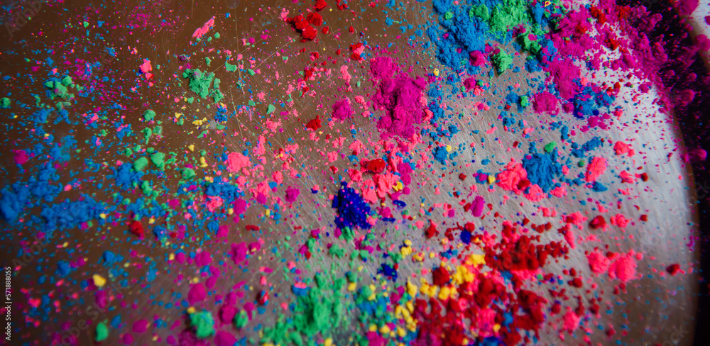 Multicolored Holi paints poured on a metal tray. Color background for the Indian national holiday Happy Holi with empty copyspace