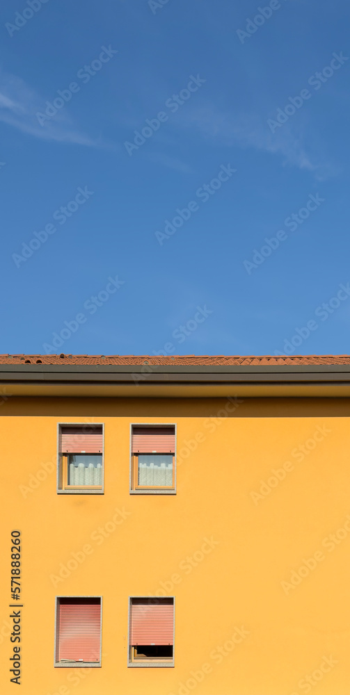 Blue sky and yellow house vertical background