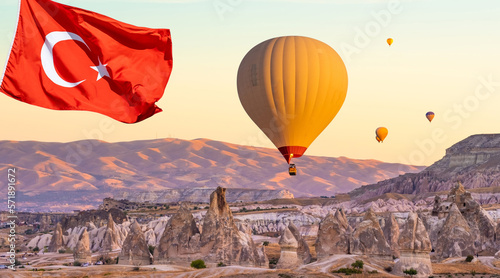 Turkey flag against hot air balloons flying on sunset sky in Cappadocia, Turkey