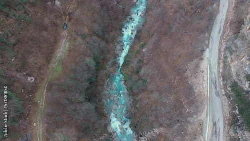 Drone Video overhead looking down a crystal clear stream river up In the mountains and an Old arch bridge photo