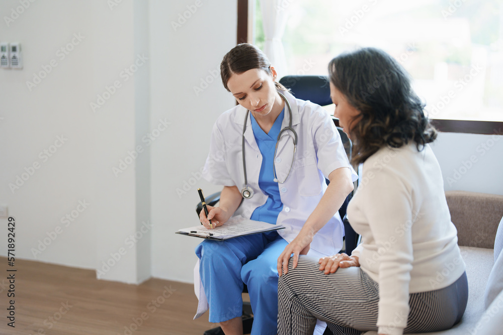 Obraz premium Portrait of a female doctor talking to a patient with knee pain.