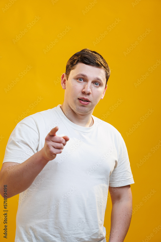 Excited young man pointing index fingers at camera, posing over yellow studio background. Positive smiling adult male choosing and indicating.I Pick You Excited young man pointing index fingers at camera, posing over yellow studio background. Positive smiling adult male choosing and indicating.I Pick You