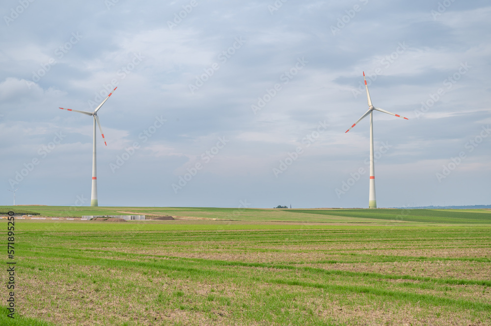 Wind park with two wind turbines with agricultural field in front during cloudy day, mainz, germany Wind park with two wind turbines with agricultural field in front during cloudy day, mainz, germany