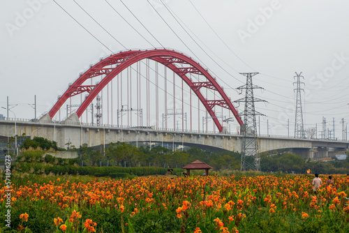 Bridge across the river with red arches next to the city garden