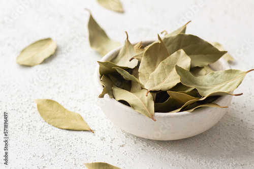 Dried bay leaves in bowl on rustic background, Spices and herbs concept (Laurus nobilis) photo