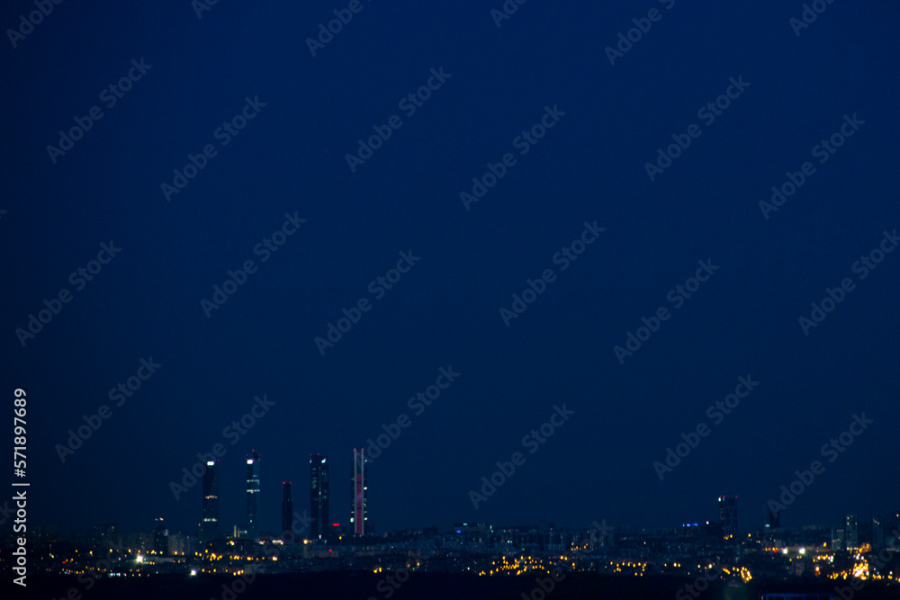 The four towers of Madrid, actually five, at night. You can see the skyline of the city