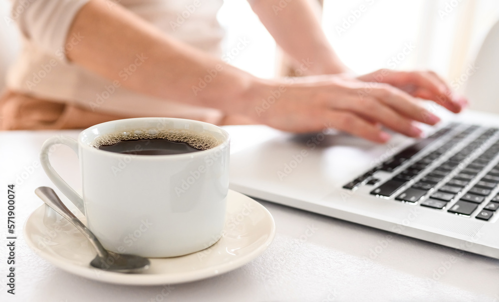 Girl typing on a laptop keyboard and drinking a coffee Girl typing on a laptop keyboard and drinking a coffee