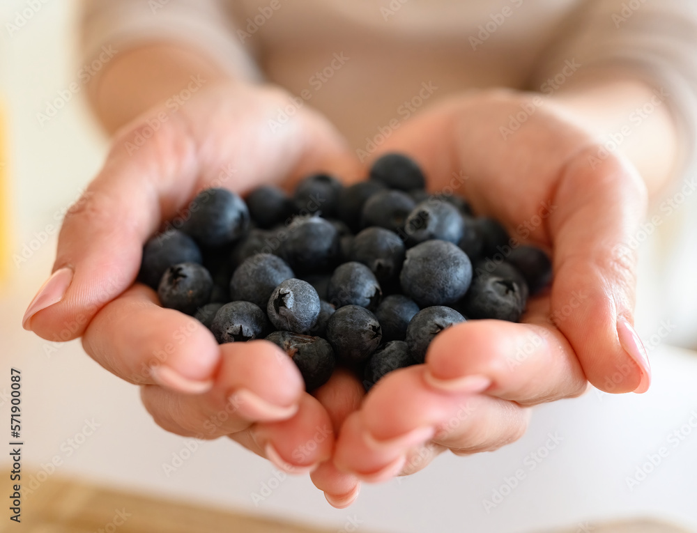 Girl holding blueberry in hands, Handful of berries Girl holding blueberry in hands, Handful of berries