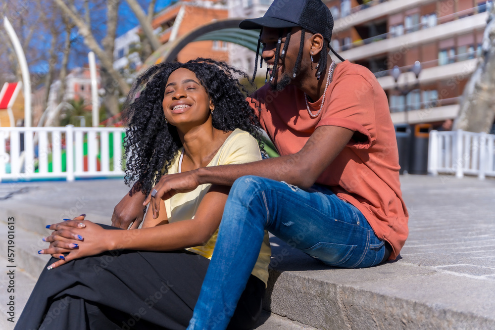 Young african american women in the city, lifestyle concept friends, sitting in a park laughing