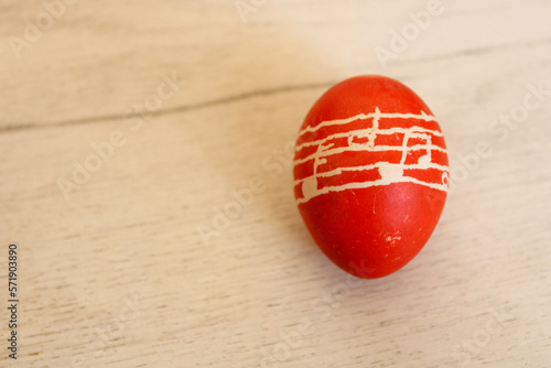 Single Easter egg on a wooden table for greetings and background 