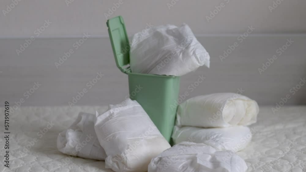 many dirty full baby diapers on floor bed or in blue trash plastic bag